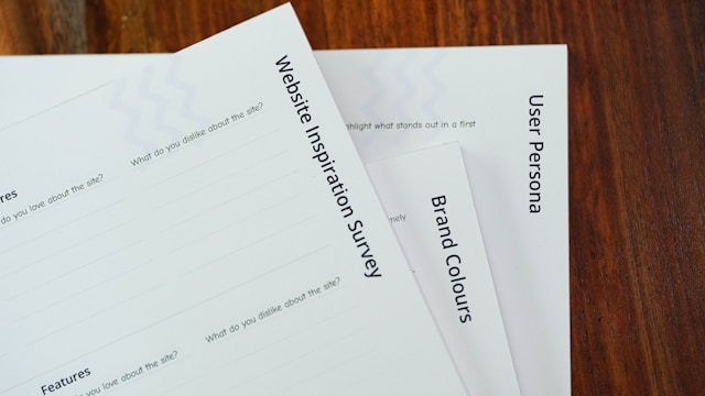 Questionários impressos sobre uma mesa de madeira